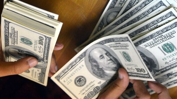 Мужчина пересчитывает доллары США. Архивное фото - Sputnik Кыргызстан
