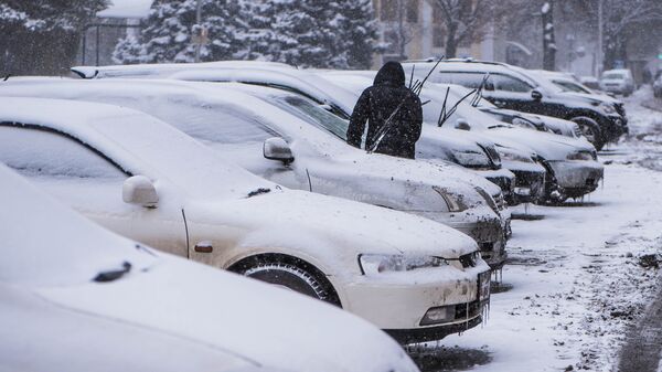 Водитель у своего авто во время снегопада в Бишкеке. Архивное фото - Sputnik Кыргызстан