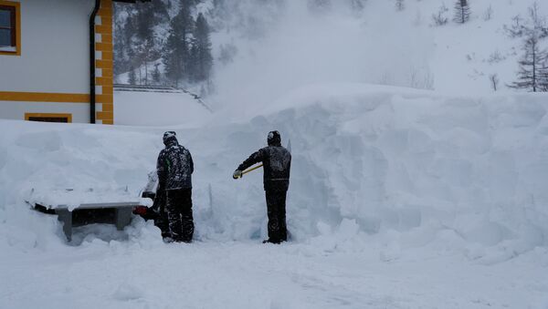 Двое рабочих убирают снег после сильного снегопада в Обертауэрне, Австрия, 10 января 2019 года - Sputnik Кыргызстан