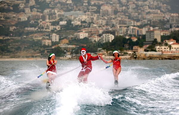 Две Снегурочки и Санта Клаус, участники Ливанского клуба водных лыж покоряют волны на лыжах - Sputnik Кыргызстан