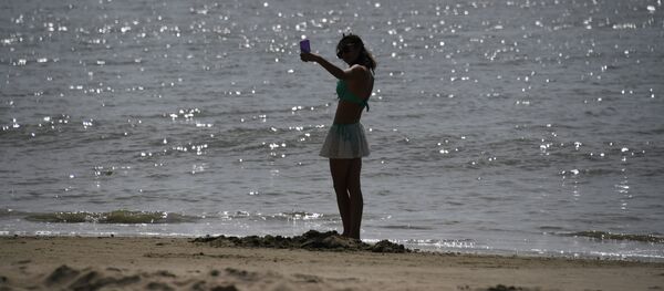 Девушка делает селфи на китайского островеа Хайнань. Архивное фото Девушка делает селфи на китайского островеа Хайнань. Архивное фото - Sputnik Кыргызстан