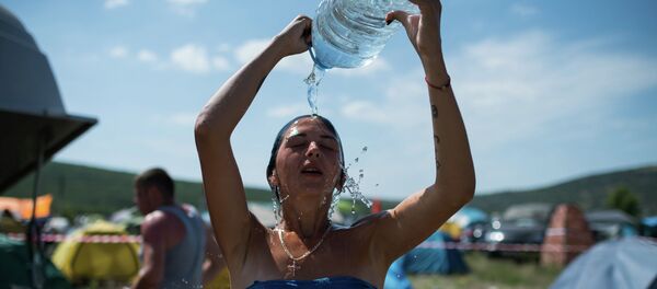Девушка обливается водой в жаркую погоду. Архивное фото - Sputnik Кыргызстан