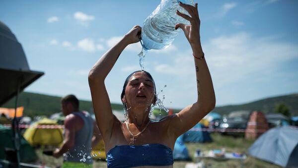 Девушка обливается водой в жаркую погоду. Архивное фото - Sputnik Кыргызстан