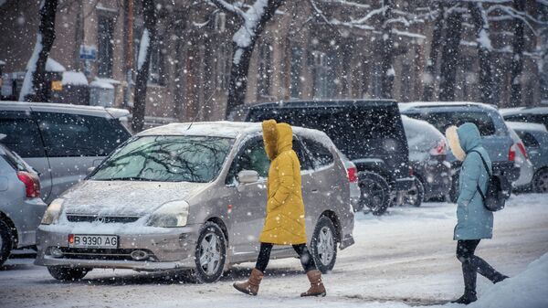 Девушки переходят дорогу во время снегопада в Бишкеке. Архивное фото - Sputnik Кыргызстан