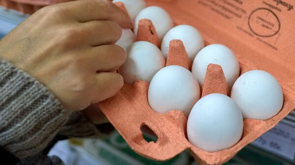 Покупатель выбирает куриные яйца в магазине. Архивное фото - Sputnik Кыргызстан