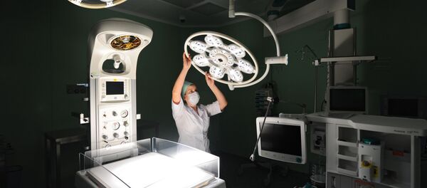 Медицинская сестра регулирует лампу в операционном отделении. Архивное фото - Sputnik Кыргызстан
