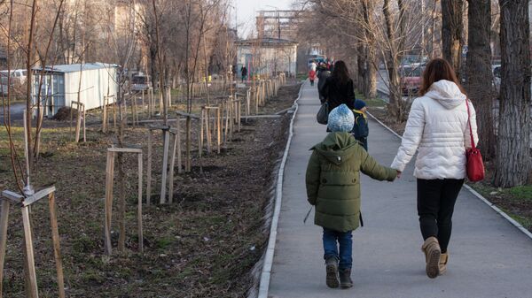 Женщина с ребенком идут по тротуару на одной из улиц Бишкека - Sputnik Кыргызстан
