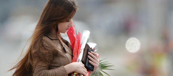 Кыз гүлдөр менен шаардын көчөсүндө басып жүргөн убакытта. Архив - Sputnik Кыргызстан