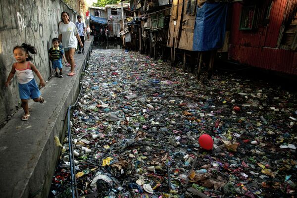 Дүйнөлүк суу ресурстары күнүнө карата (22-март) адамдар таштандыга толгон Маниладагы (Филиппин) каналдын жээгин бойлой басышат - Sputnik Кыргызстан