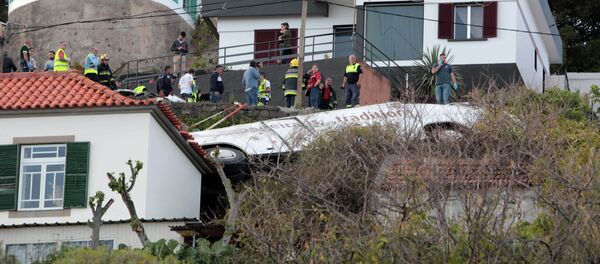 Спасатели стоят рядом с обломками автобуса после аварии в Канико на португальском острове Мадейра, 17 апреля 2019 года - Sputnik Кыргызстан