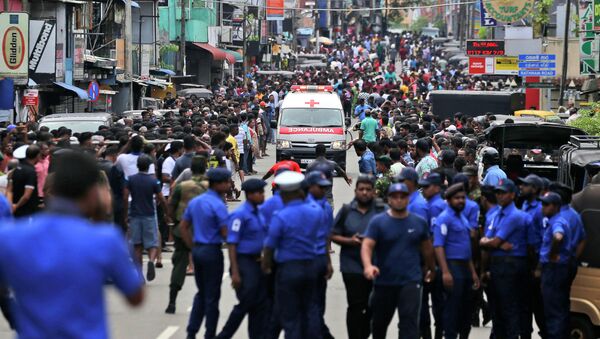 Полицейские Шри-Ланки расчищают дорогу, когда машина скорой помощи проезжает с ранеными во время церковных взрывов в Коломбо, Шри-Ланка, в воскресенье, 21 апреля 2019 - Sputnik Кыргызстан