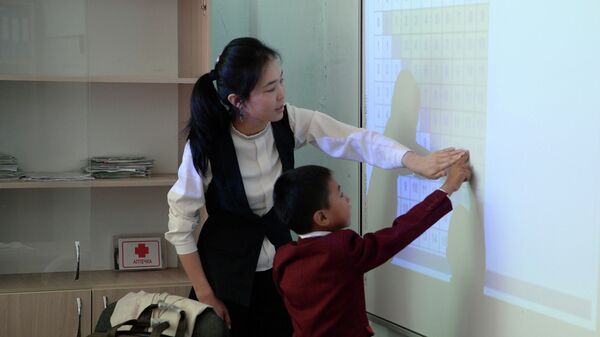 Учительница объясняет ученику тему во время урока в школе в Бишкеке. Архивное фото - Sputnik Кыргызстан