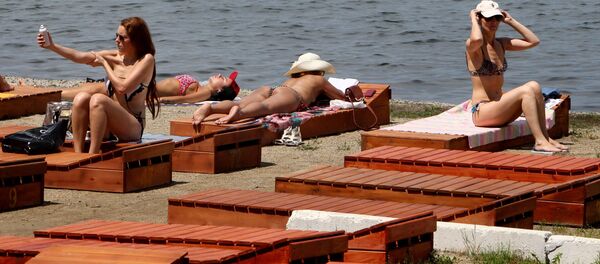 Женщины загарают на шезлонгах на берегу моря. Архивное фото Женщины загарают на шезлонгах на берегу моря. Архивное фото - Sputnik Кыргызстан