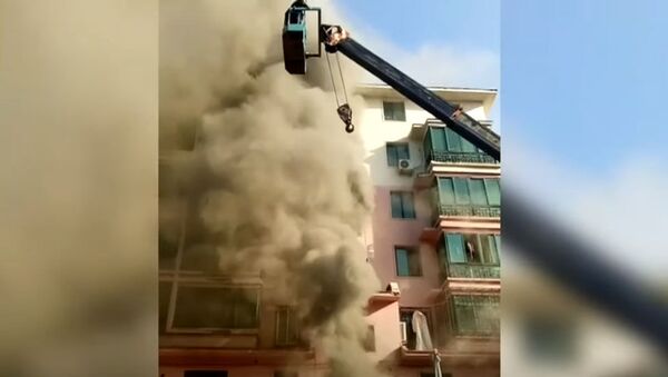 Строитель на кране спас 14 человек из полыхающей многоэтажки в Китае. Видео - Sputnik Кыргызстан