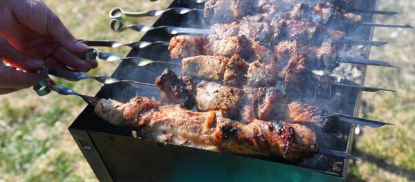 Человек жарит шашлык на мангале. Архивное фото - Sputnik Кыргызстан