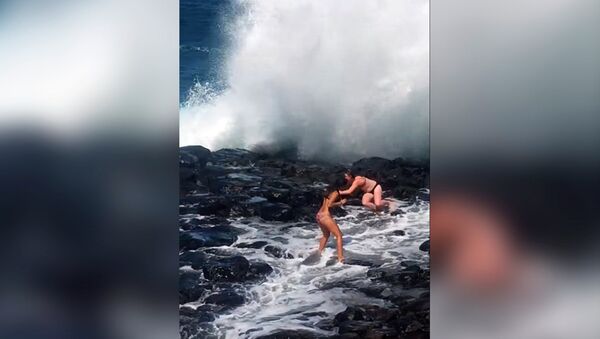Двух любительниц селфи в бикини смыло огромной волной на Гавайях. Видео - Sputnik Кыргызстан