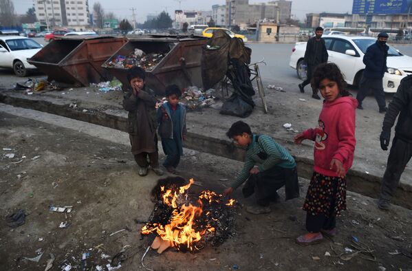 Афганские дети жгут пластик, чтобы согреться у костра на обочине дороги в Кабуле - Sputnik Кыргызстан