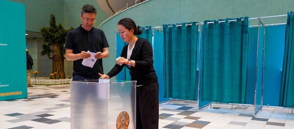 Люди голосуют на внеочередных выборах президента Казахстана во Дворце школьников в Нур-Султане. Люди голосуют на внеочередных выборах президента Казахстана во Дворце школьников в Нур-Султане. - Sputnik Кыргызстан