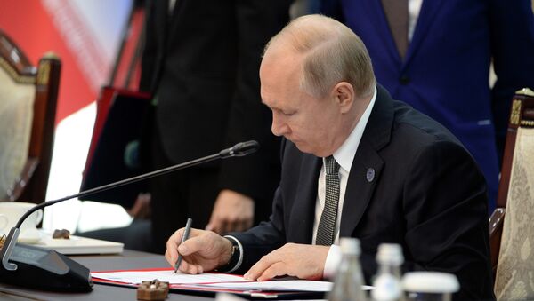 Владимир Путин подписывает документ. Архивное фото - Sputnik Кыргызстан