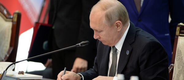Владимир Путин подписывает документ. Архивное фото - Sputnik Кыргызстан