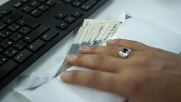 Мужчина держит конверт с деньгами на столе. Иллюстративное фото - Sputnik Кыргызстан