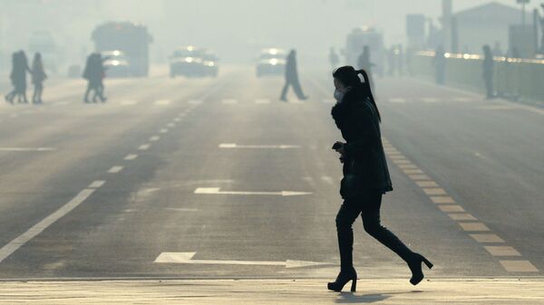 Девушка в медицинской маске переходит дорогу в Пекине. Архивное фото - Sputnik Кыргызстан
