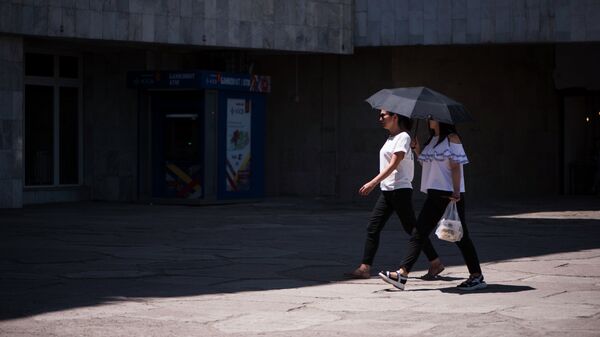 Девушки идут по улице зонтом укрываясь от солнца. Архивное фото - Sputnik Кыргызстан