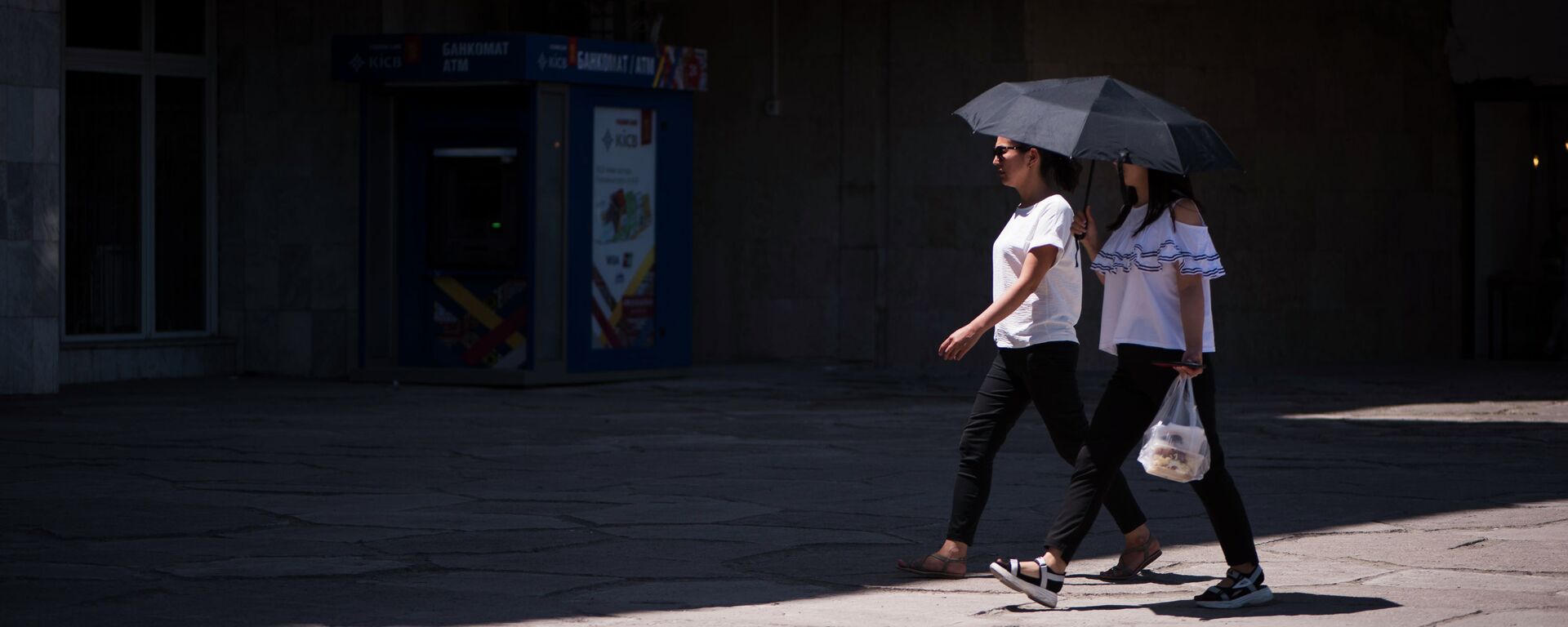 Девушки с зонтом идут во время жаркой погоды в Бишкеке. Архивное фото - Sputnik Кыргызстан, 1920, 01.05.2021