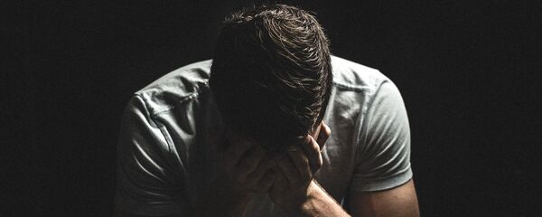 Киши бетин жабып отуруп жатат. Архив - Sputnik Кыргызстан