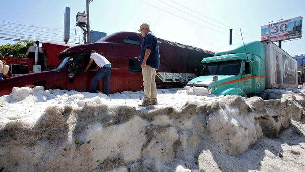 Мужчины стоят рядом с грузовиками заваленными снегом в мексиканском городе Гвадалахара. 30 июня 2019 год - Sputnik Кыргызстан