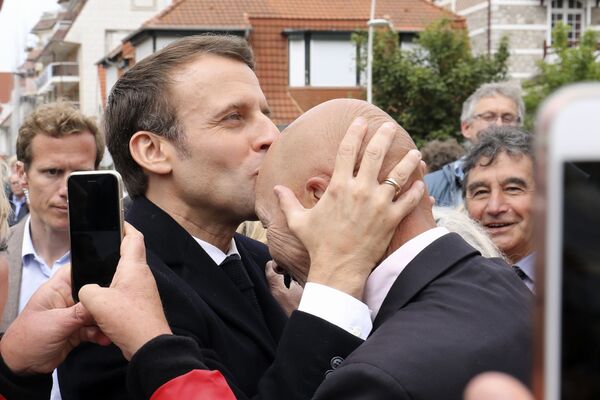 Президент Франции Эммануэль Макрон целует сторонника после голосования на выборы в европарламент в Ле-Туке на севере Франции - Sputnik Кыргызстан