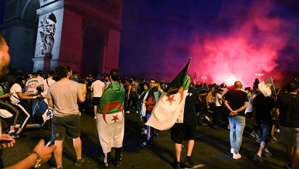 Алжирские болельщики празднуют победу их команды на четвертьфинале футбольного матча Кубка наций Африки (CAN) 2019 между Кот-д'Ивуаром и Алжиром около Триумфальной арки в Париже, 11 июля 2019 года - Sputnik Кыргызстан