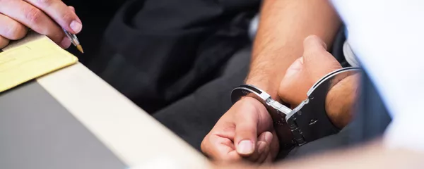 Задержанный мужчина в наручниках. Архивное фото Задержанный мужчина в наручниках. Архивное фото - Sputnik Кыргызстан