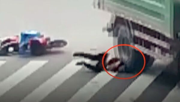 Мотоциклист угодил головой под колесо грузовика, но избежал смерти. Видео - Sputnik Кыргызстан