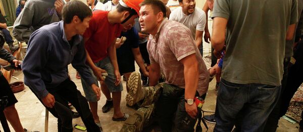 Сторонники бывшего президента Кыргызстана Алмазбека Атамбаева окружают сотрудника сил государственной безопасности, который был ранен во время операции по задержанию Атамбаева - Sputnik Кыргызстан