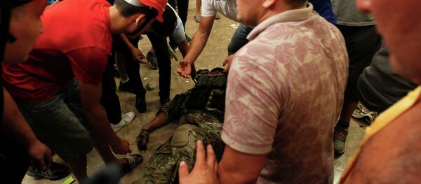 Сторонники бывшего президента Кыргызстана Алмазбека Атамбаева окружают сотрудника сил государственной безопасности, который был ранен во время операции по задержанию Атамбаева - Sputnik Кыргызстан