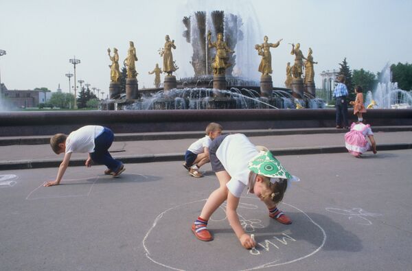 Дети рисуют мелом на асфальте у фонтана Дружба народов в Москве. 1984 - Sputnik Кыргызстан