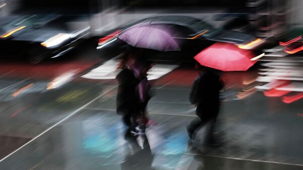 Пешеходы идут по улице во время сильного дождя. Архивное фото - Sputnik Кыргызстан