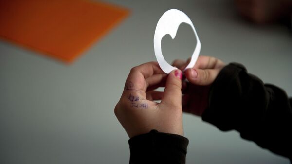 Девочка держит в руках бумажку в форме сердца. Архивное фото - Sputnik Кыргызстан