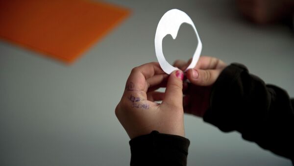 Девочка держит в руках бумажку в форме сердца. Архивное фото - Sputnik Кыргызстан