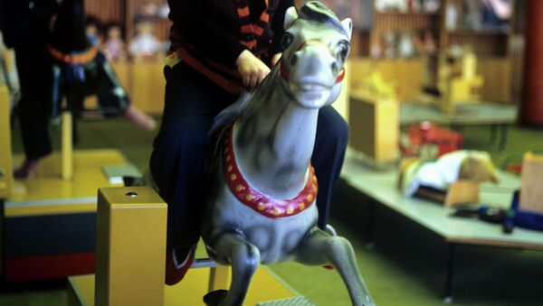 Мальчик играет на игрушечной лошади. Архивное фото - Sputnik Кыргызстан