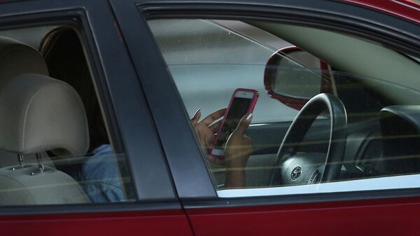 Девушка водитель пользуется телефоном во время езды на автомобиле. Архивное фото - Sputnik Кыргызстан
