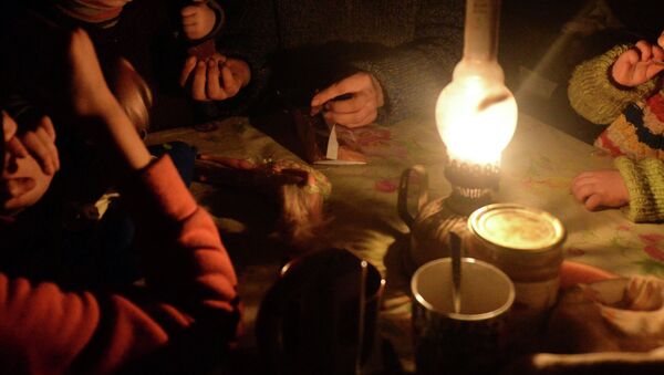 Семья сидят за столом освещенная керосиновой лампой. Архивное фото - Sputnik Кыргызстан
