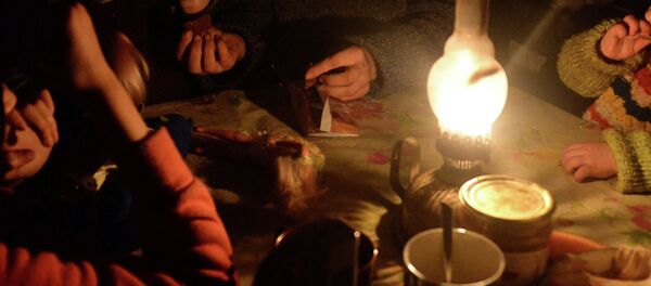 Семья сидят за столом освещенная керосиновой лампой. Архивное фото - Sputnik Кыргызстан