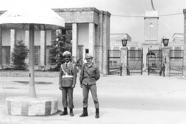 Военный переводчик Айбек Дехканов и афганский полицейский возле дворца президента Бабрака Кармаля, 1983 год - Sputnik Кыргызстан