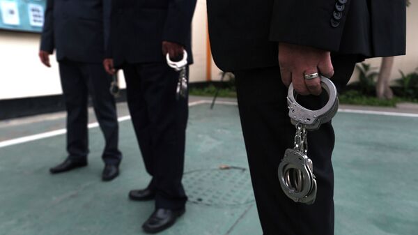 Сотрудники МВД с наручниками ожидают подозреваемых. Архивное фото - Sputnik Кыргызстан