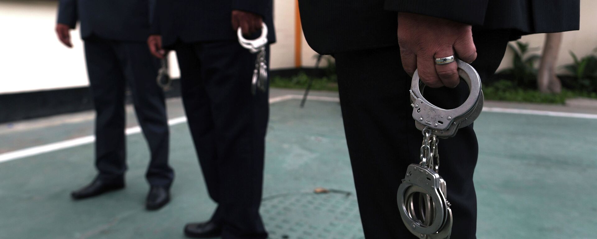 Сотрудники правоохранительных органов с наручниками в руках. Архивное фото - Sputnik Кыргызстан, 1920, 22.02.2022