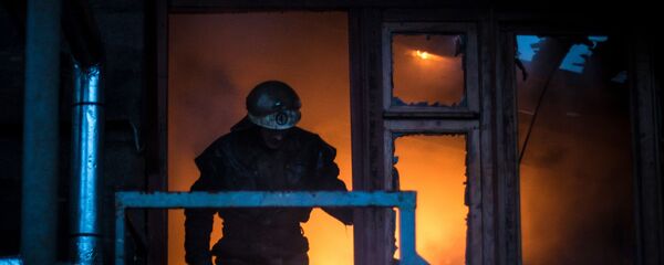 Пожарный выходит из горящего дома. Архивное фото Пожарный выходит из горящего дома. Архивное фото - Sputnik Кыргызстан