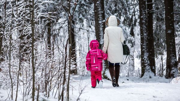 Женщина с ребенком идут в городском парке после снегопада. Архивное фото - Sputnik Кыргызстан