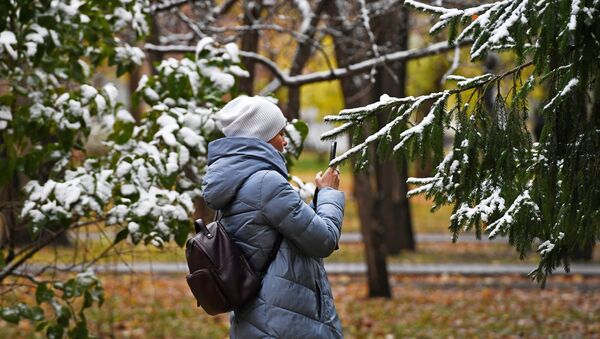 Девушка фотографирует выпавший снег. Архивное фото - Sputnik Кыргызстан